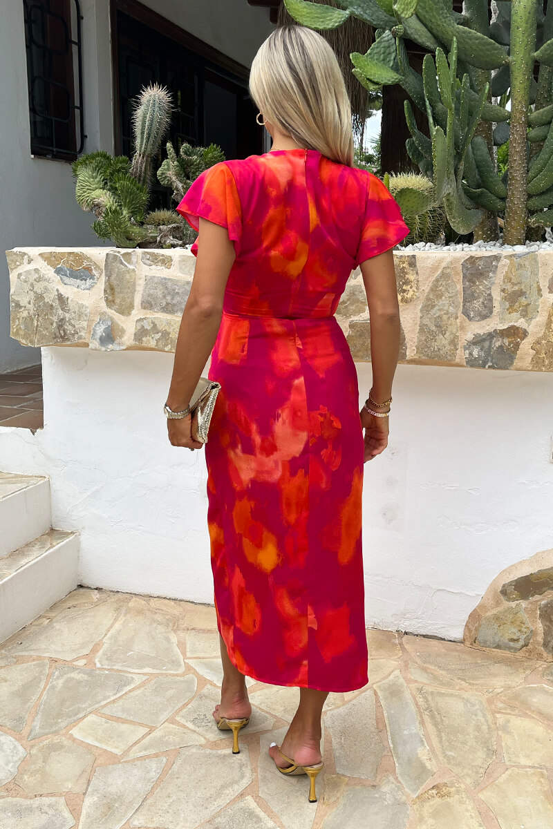 Vestido midi cruzado con mangas acampanadas y estampado de manchas rosas y naranjas