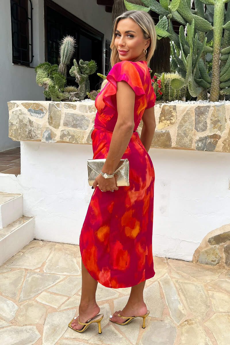 Vestido midi cruzado con mangas acampanadas y estampado de manchas rosas y naranjas